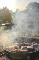 Preparing Barbeque BBQ Campfire and sausages meat steak chicken Germany. photo