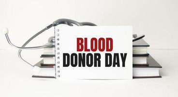 blood donor day words on notebook and stethoscope on wooden background photo