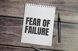 el miedo al fracaso la mesa de trabajo es ligera. texto en la página del bloc de notas.