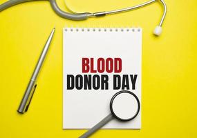 blood donor day words on notebook and stethoscope on yellow background photo