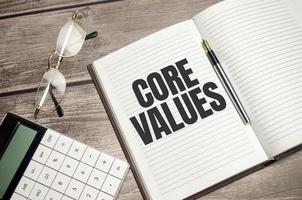 text core values on brown diary with calculator, glasses on wooden background photo