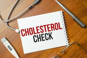 cholesterol check with pen and stethoscope on wooden background photo