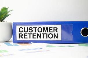 customer retention word on file folder and charts on white background photo