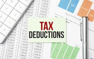 tax deductions words on notebook and pen, calculator and charts photo