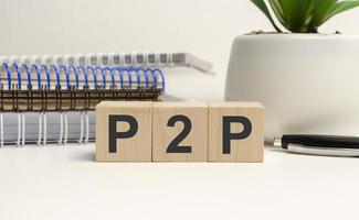 P2P abbreviation written in wooden blocks. Peer to peer business concept photo