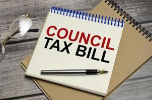 Office workplace table with glasses and pen the text coUNCIL TAX BILL photo