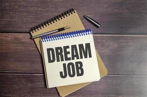 dream job words on paper notebook on wooden background photo