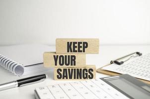 Keep Your Savings words on wooden background and charts photo