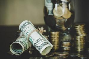 dollars with coins in jug glass photo