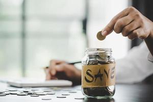 woman hand putting money into jar photo