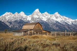 Iconic wooden barn in field with background of Grand Teton. photo
