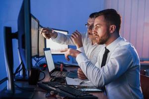 Stressful work. Two stock traders is in the office with exchange technology on monitors photo