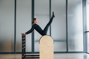 Using special equipment. Woman in sportive clothes is in the studio photo