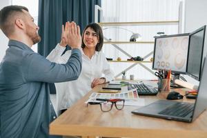 Giving high five. Two designers working together in the office photo