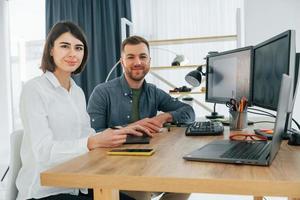 mirando a la cámara. dos diseñadores trabajando juntos en la oficina foto