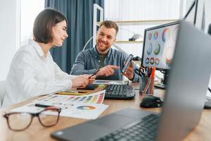 hablando y creando contenido. dos diseñadores trabajando juntos en la oficina foto