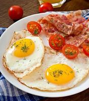 English breakfast - toast, egg, bacon and vegetables in a rustic style on wooden background photo