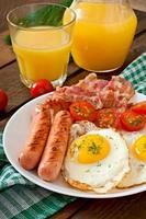 English breakfast - toast, egg, bacon and vegetables in a rustic style on wooden background photo