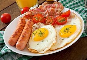 English breakfast - toast, egg, bacon and vegetables in a rustic style on wooden background photo