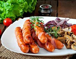 Fried sausages with vegetables on a white plate photo