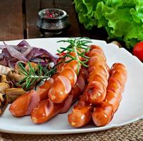 Fried sausages with vegetables on a white plate photo