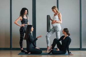 Yoga session. Women in sportive clothes standing in the fitness center photo