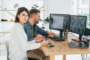 hablando entre ellos sobre nuevas ideas. dos diseñadores trabajando juntos en la oficina foto