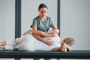 Massaging the back. Woman is in health center getting help by doctor photo