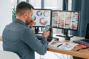 Using different colors. Male designer working in the office by using PC photo