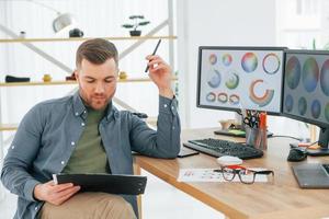 With tablet in hands. Male designer working in the office by using PC photo