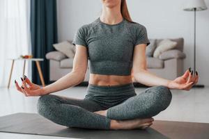 Domestic room. Young woman with slim body type and in yoga clothes is at home photo