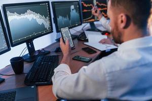 Using the phone. Two stock traders working in the office with exchange technology photo