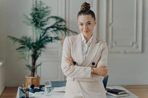 Happy businesswoman in classic wear posing in light modern office photo