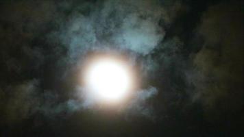luz de la luna llena por la noche en el cielo, las nubes pasaron lentamente video