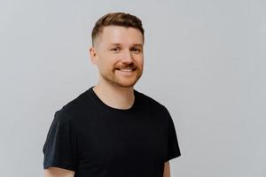 Handsome redhead man feeling happy and expressing positivity photo