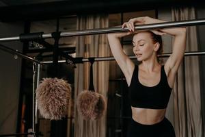 Beautiful redhead fitness woman relaxing on pilates cadillac reformer photo