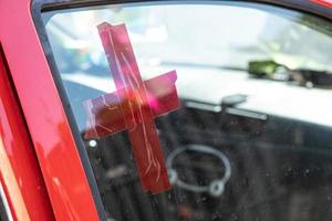 KHARKIV, UKRAINE - May, 04, 2022. Red cross on the glass of the car. Volunteer help. Medical service. Delivery of food and medicine to people affected by the Russian invasion of Ukraine. photo