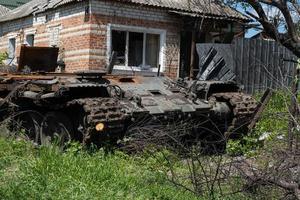 KHARKIV, UKRAINE - May, 04, 2022. A burnt Russian tank near a residential building. War in Ukraine 2022. Russian missiles in Kharkiv countryside Ukraine. Russian attack on Ukraine. photo