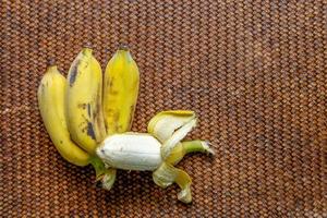 Group of bananas on brown wooden background. photo