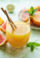 Glass of juice and citrus fruits photo