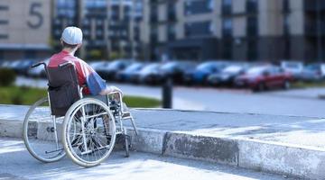 un hombre discapacitado en silla de ruedas en la ciudad. foto