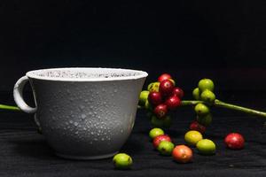 Photo of a cup of black coffee and fresh original coffee beans on a black background. Perfect for the design elements of the barista, coffee shop and coffee industry.