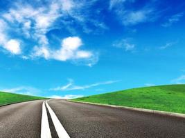 Asphalt car road and clouds on blue sky in summer day photo