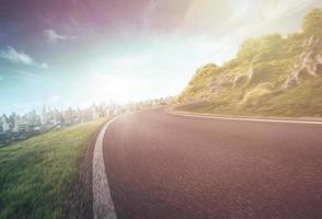 Empty long mountain road to the horizon on a sunny summer day at a bright sunset - speed motion blur effect. photo