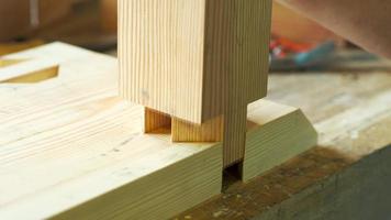 woodworker assembles furniture on a dovetail joint