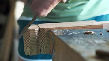 a woodworker cuts a profile of a leg out of wood with a chisel video