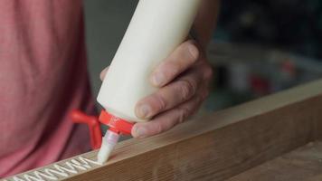 woodworker applies glue to the workpiece with a snake video