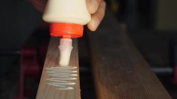 woodworker applies glue to the workpiece with a snake video