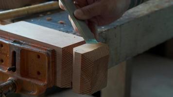 un carpintero corta un perfil de una pierna de madera con un cincel video