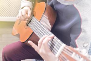 aprendiendo a tocar la guitarra. educación musical. niño tocando guitarra acústica. foto